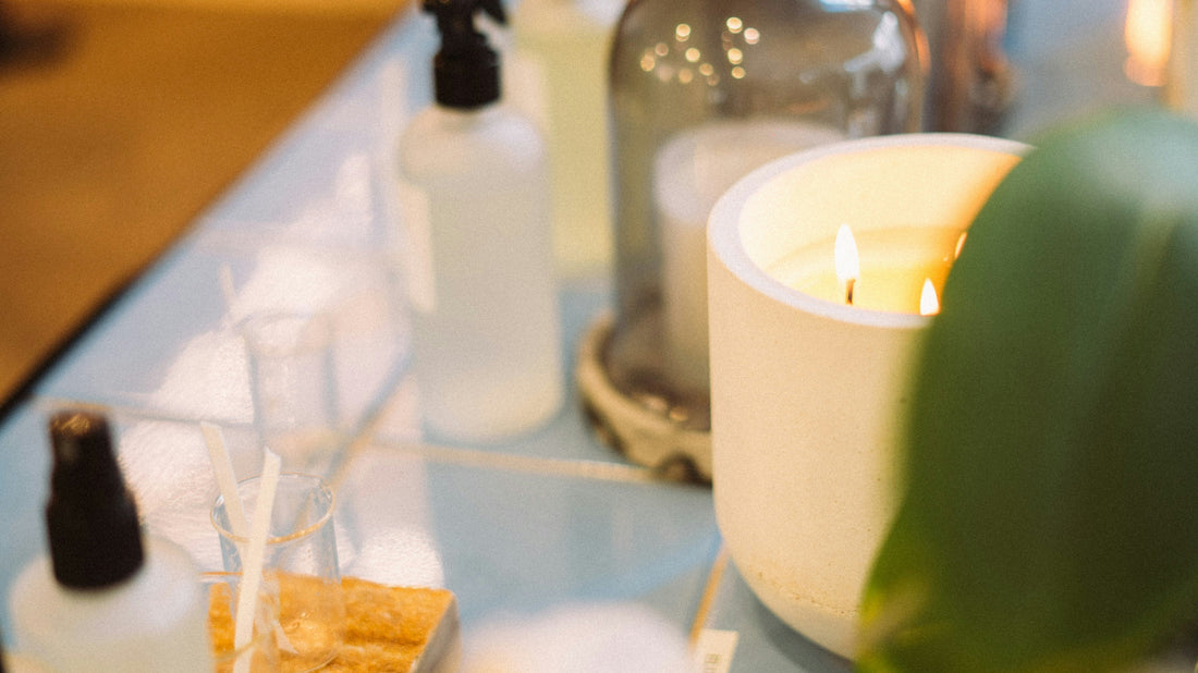 Wellness bottles and lit candle on a clean surface